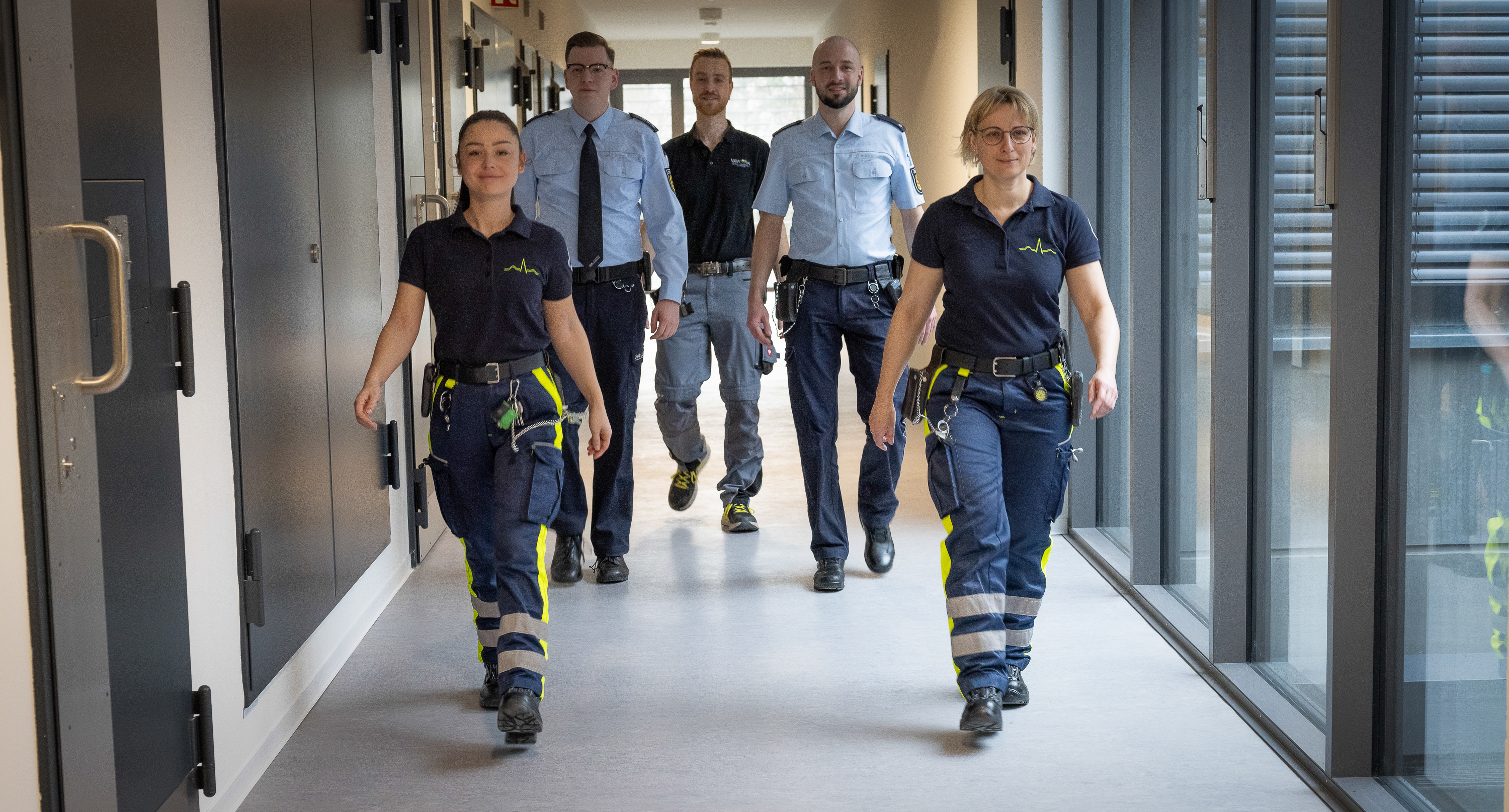 Justizvollzugsbeamte laufen durch einen Gang innerhalb der Justizvollzugsanstalt